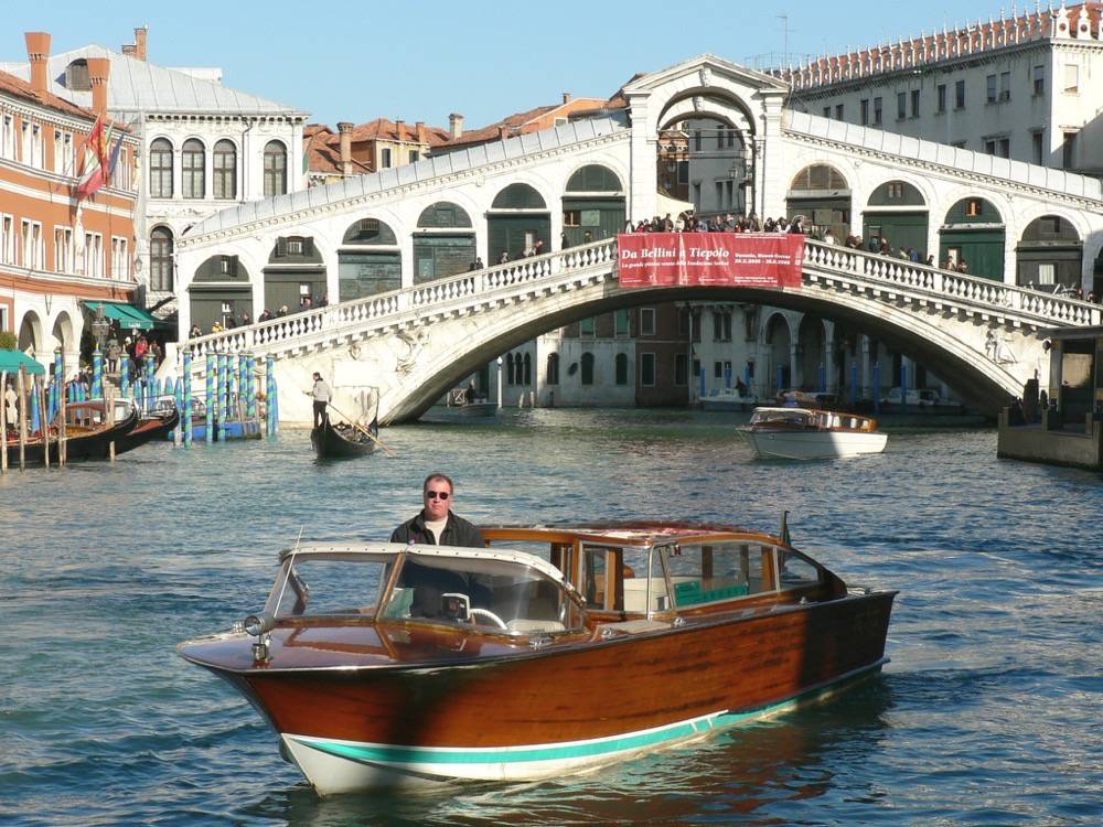 Luigi on his boat with Rialto bridge in the background for tours with Venice qualified tour guide